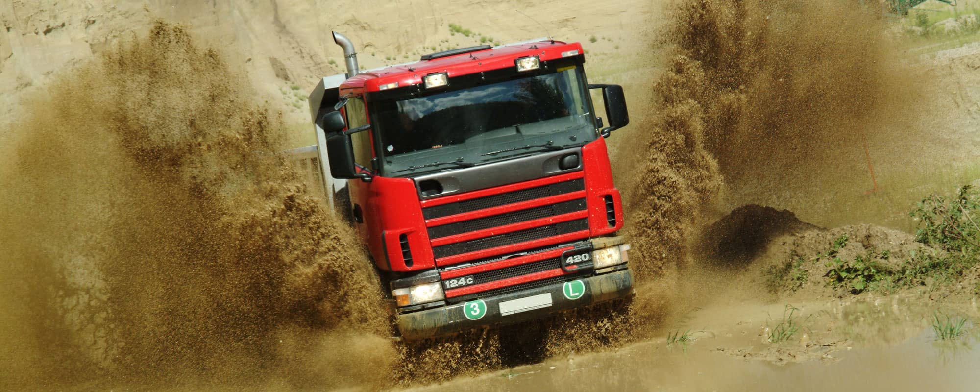 Lorry driver splashing through water in North Wales quarry